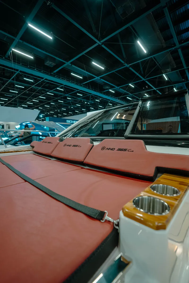 Slide: The Image of 2025 NHD 365 HT PLUS boat interior with red seating and cup holders. - 27