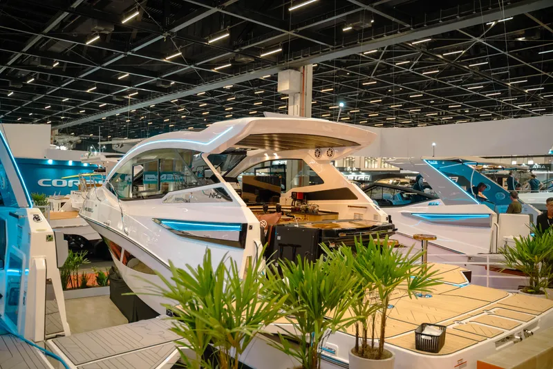 Slide: The Image of 2025 NHD 365 HT PLUS luxury yacht displayed at a boat show, surrounded by plants. - 6