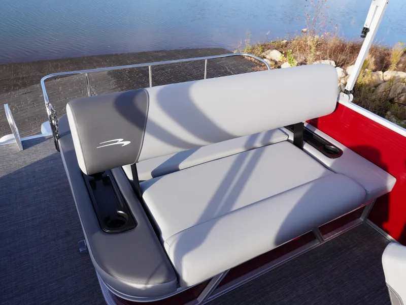 Slide: The Image of 2025 Bennington 22 SVSB boat seat with gray upholstery and cup holders by the water. - 20