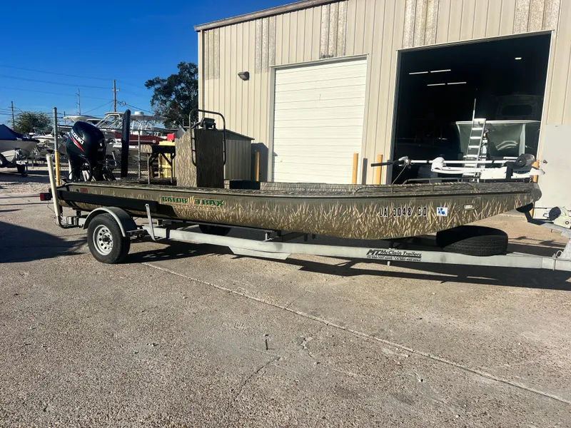 Slide: The Image of 2015 Gator Trax 18 boat on trailer, parked outside a building. - 1