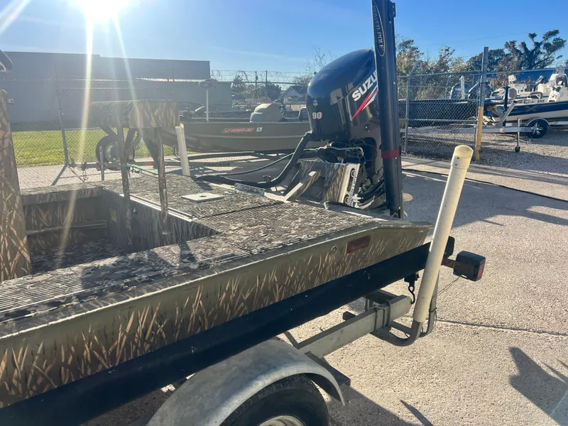 Slide: The Image of 2015 Gator Trax 18 boat with Suzuki outboard motor on a trailer in sunny setting. - 4