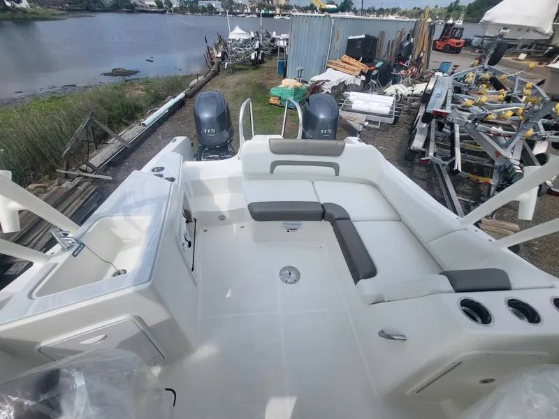 Slide: The Image of 2024 World Cat 230 SD boat interior with seating and dual engines, dockside view. - 4