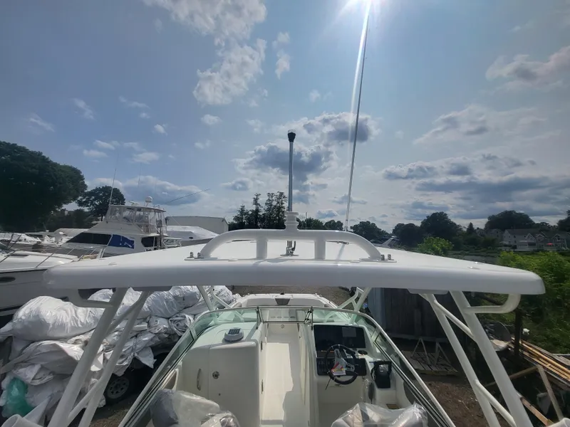 Slide: The Image of 2024 World Cat 230 SD boat with T-top, docked under a sunny sky. - 8