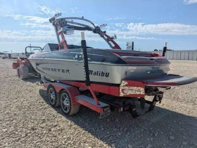 Slide: The Image of 2014 Malibu Wakesetter 22 MXZ boat on a trailer, parked on gravel. - 13