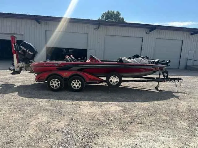 Slide: The Image of 2007 Ranger Z21 Comanche boat with trailer parked outside a warehouse. - 0