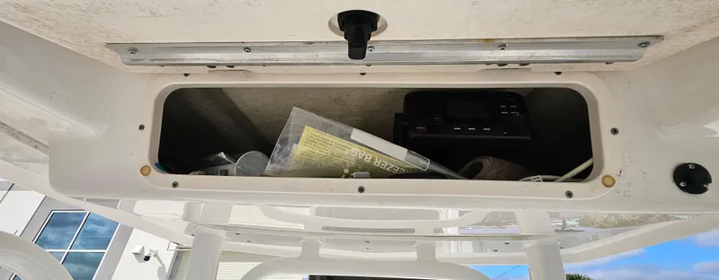 Slide: The Image of Storage compartment on a 2018 Robalo 246 Cayman boat, containing various items. - 13