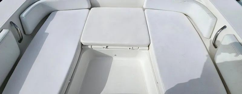 Slide: The Image of 2018 Robalo 246 Cayman boat seating area with white cushioned seats. - 14