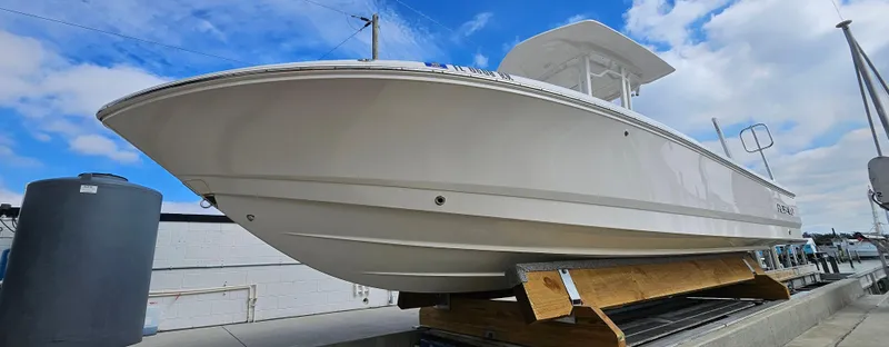 Slide: The Image of 2018 Robalo 246 Cayman boat on display under a blue sky. - 2