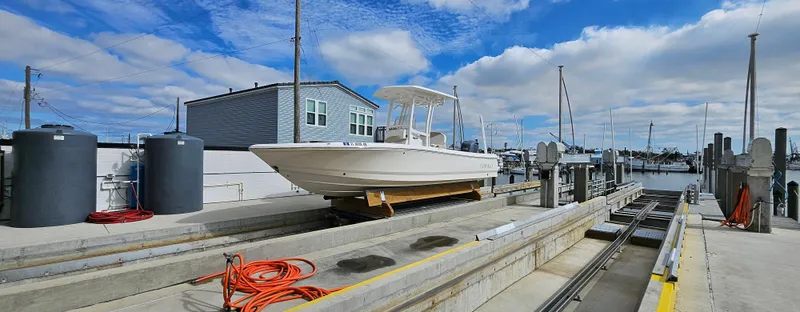 Slide: The Image of 2018 Robalo 246 Cayman boat on a dock under a partly cloudy sky. - 20