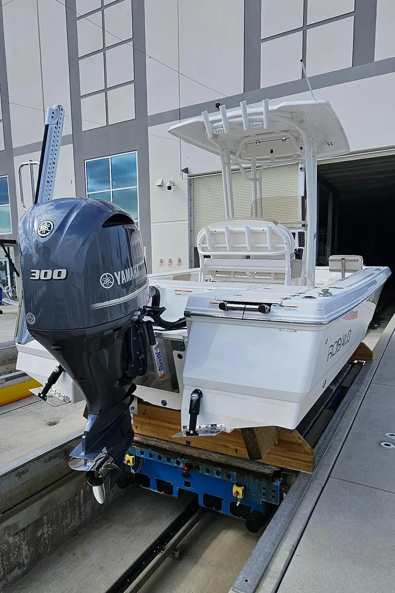 Slide: The Image of 2018 Robalo 246 Cayman boat with Yamaha 300 engine, docked near a building. - 22