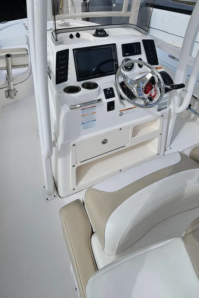 Slide: The Image of 2018 Robalo 246 Cayman boat console with steering wheel and navigation controls. - 23