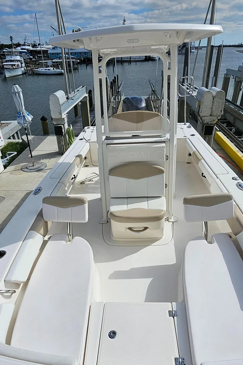 Slide: The Image of 2018 Robalo 246 Cayman boat docked, featuring spacious seating and center console. - 25