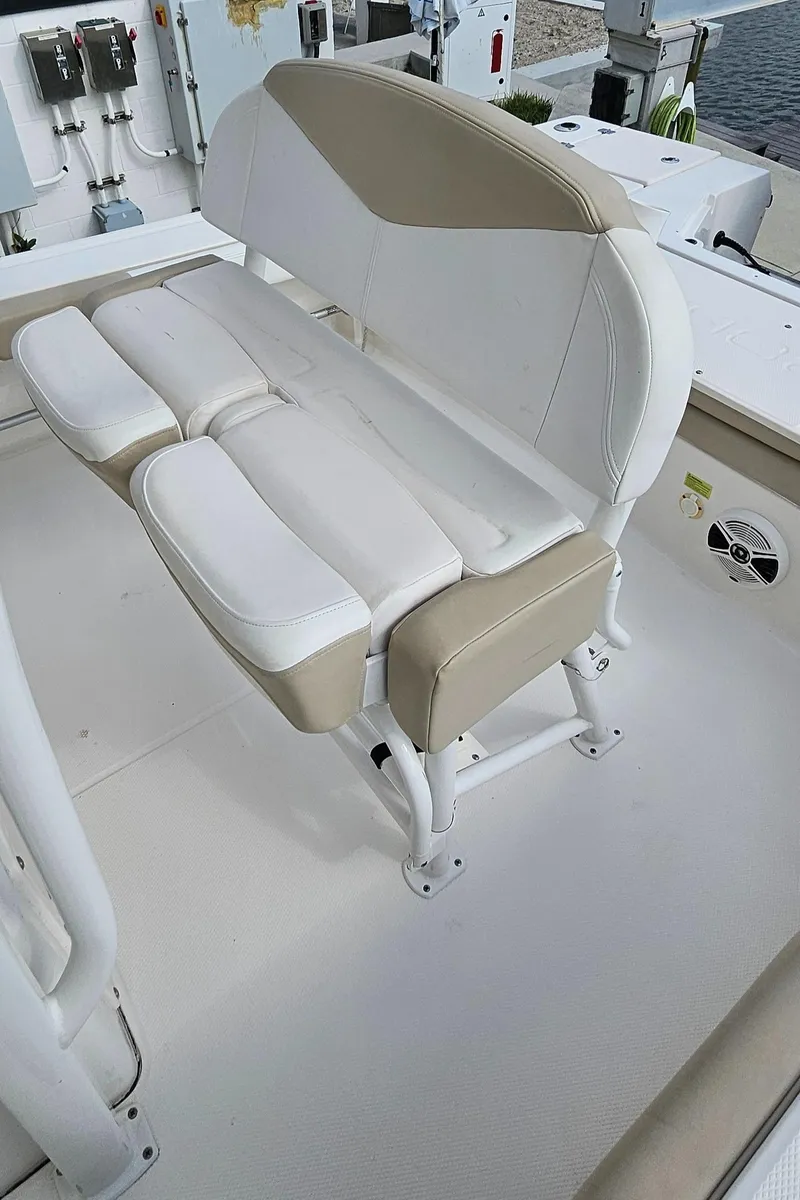 Slide: The Image of 2018 Robalo 246 Cayman boat seat, white and beige upholstery, on deck. - 29