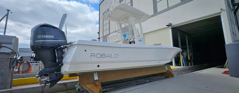 Slide: The Image of 2018 Robalo 246 Cayman boat with Yamaha engine, docked near a building. - 3