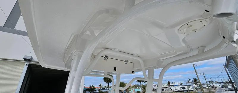 Slide: The Image of 2018 Robalo 246 Cayman boat's T-top structure against a marina backdrop. - 6