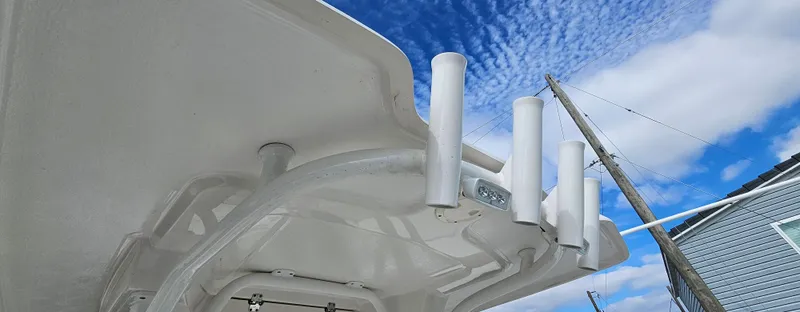 Slide: The Image of Robalo 246 Cayman 2018 boat canopy with rod holders against a blue sky. - 7