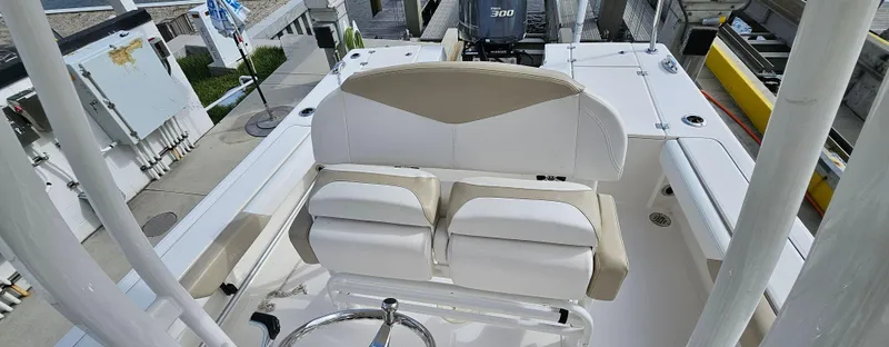 Slide: The Image of 2018 Robalo 246 Cayman boat interior with white seating and steering wheel. - 9
