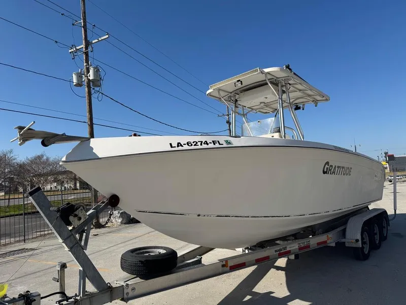 Slide: The Image of 2005 Sea Chaser 2600 CC boat on trailer, labeled "Gratitude," parked outdoors. - 10