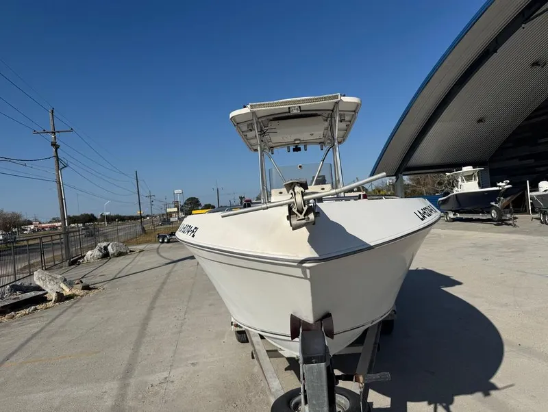 Slide: The Image of 2005 Sea Chaser 2600 CC boat on trailer, parked outdoors near a large building. - 11