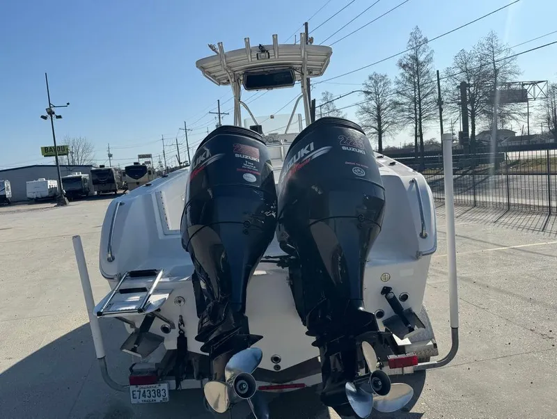 Slide: The Image of 2005 Sea Chaser 2600 CC boat with dual outboard motors in a parking lot. - 15