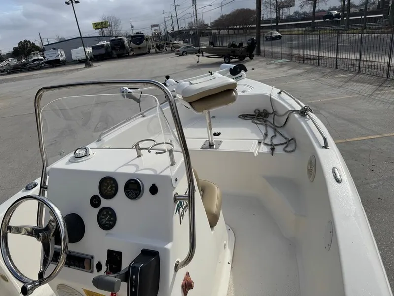 Slide: The Image of 2017 Key West 176cc boat interior with steering console and seating, parked outdoors. - 9