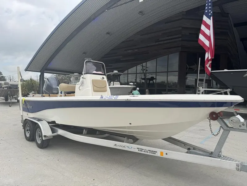 Slide: The Image of 2019 NauticStar 215 XTS boat on trailer, displayed outdoors with American flag. - 10