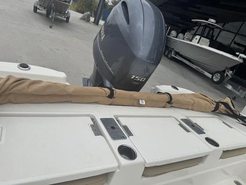 Slide: The Image of 2019 NauticStar 215 XTS boat with Yamaha 150 engine, docked outdoors. - 12