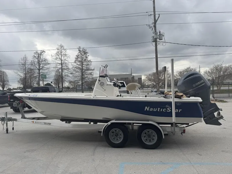 Slide: The Image of 2019 NauticStar 215 XTS boat on trailer, overcast sky background. - 2