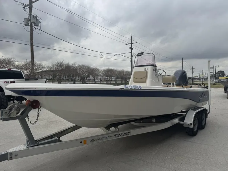 Slide: The Image of 2019 NauticStar 215 XTS boat on trailer under cloudy sky. - 3