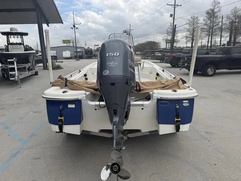 Slide: The Image of 2019 NauticStar 215 XTS boat with Yamaha 150 engine, parked outdoors. - 6
