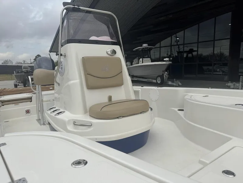 Slide: The Image of 2019 NauticStar 215 XTS boat with beige seating, displayed outdoors. - 9