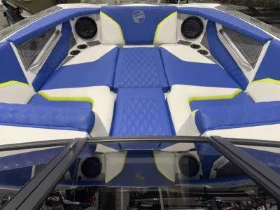 Slide: The Image of 2024 Tigé 24RZX boat interior with blue and white seating and speaker system. - 10