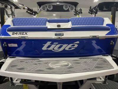 Slide: The Image of 2024 Tigé 24RZX boat, blue and white, rear view with seating and logo. - 4