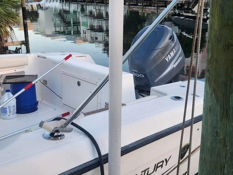 Slide: The Image of 2003 Century 2300V boat with Yamaha engine docked by calm waters. - 5