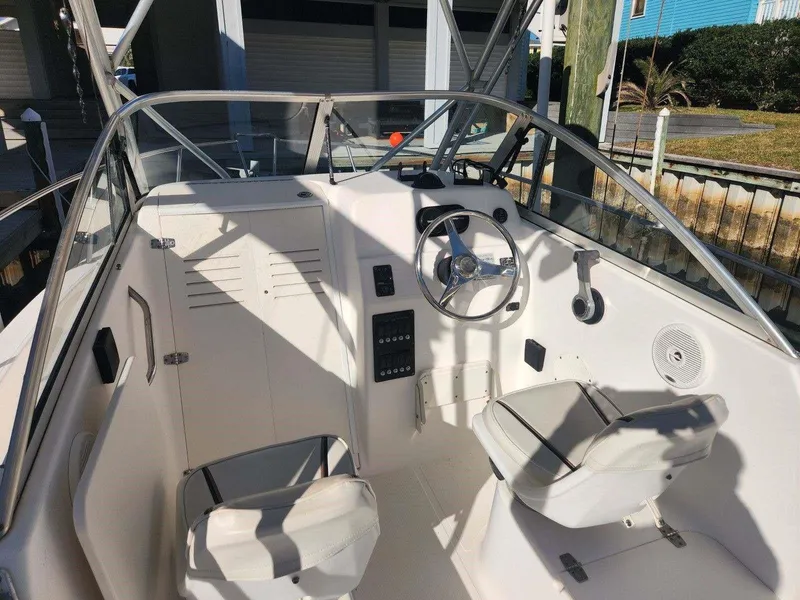 Slide: The Image of 2003 Century 2300V boat cockpit with steering wheel, seats, and control panel. - 9