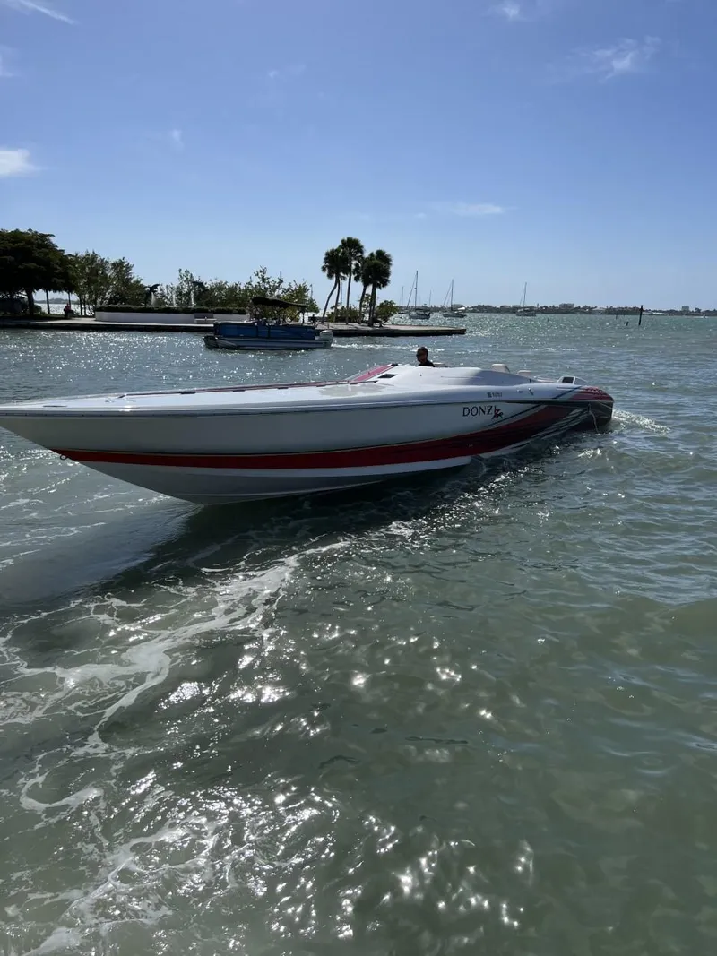 Slide: The Image of 2008 Donzi 43 ZR speedboat cruising on a sunny day near a shoreline. - 1