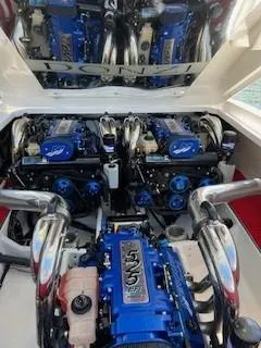 Slide: The Image of 2008 Donzi 43 ZR boat engine compartment with powerful blue engines and chrome exhausts. - 13