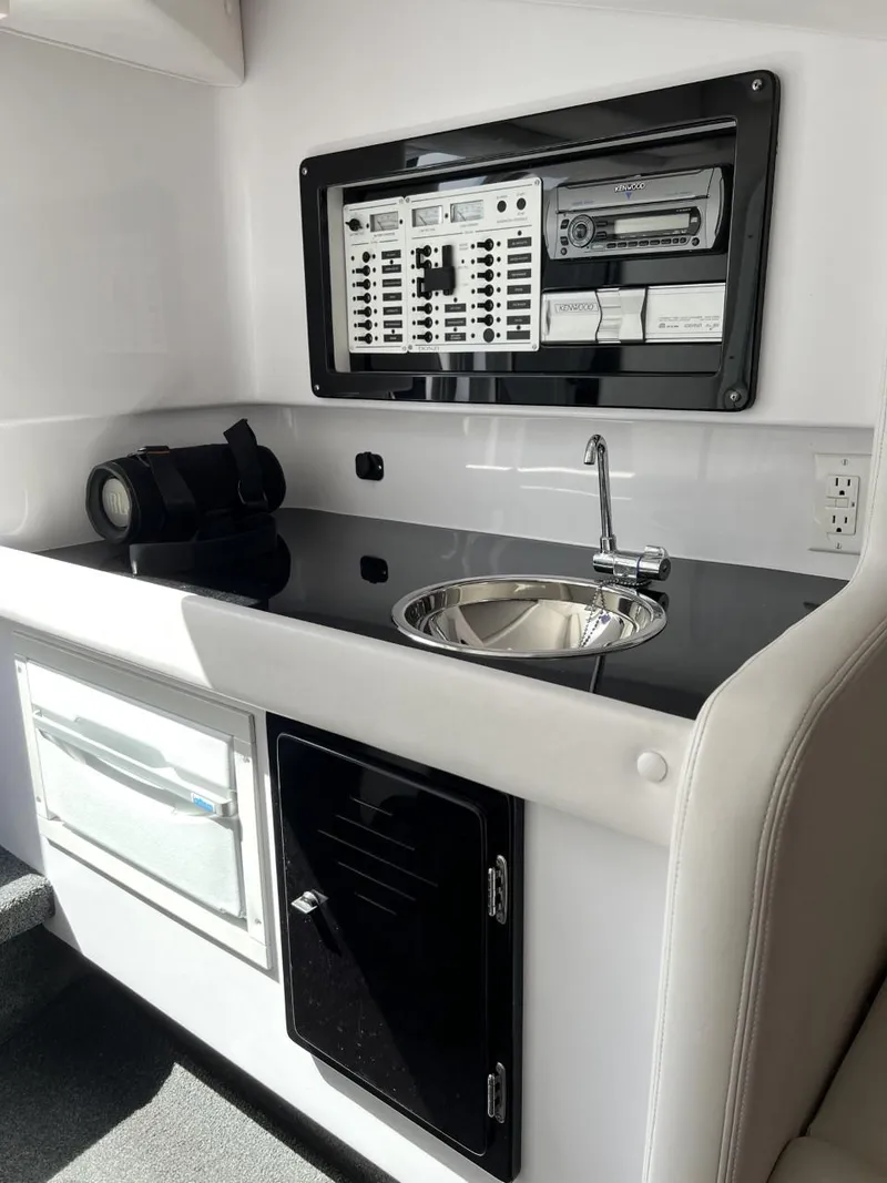 Slide: The Image of 2008 Donzi 43 ZR boat interior with sink, control panel, and storage compartments. - 25