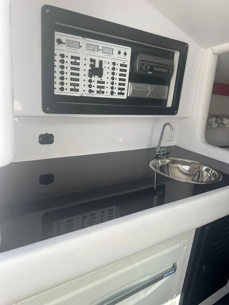 Slide: The Image of 2008 Donzi 43 ZR boat interior with control panel and sink. - 28