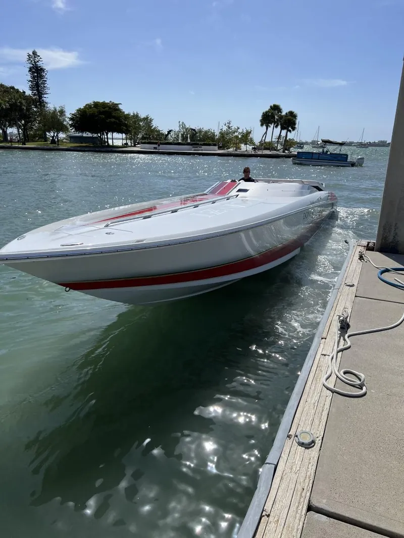 Slide: The Image of 2008 Donzi 43 ZR speedboat docked on a sunny day, with scenic waterfront background. - 3
