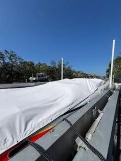 Slide: The Image of 2008 Donzi 43 ZR boat covered, docked outdoors under clear blue sky. - 32