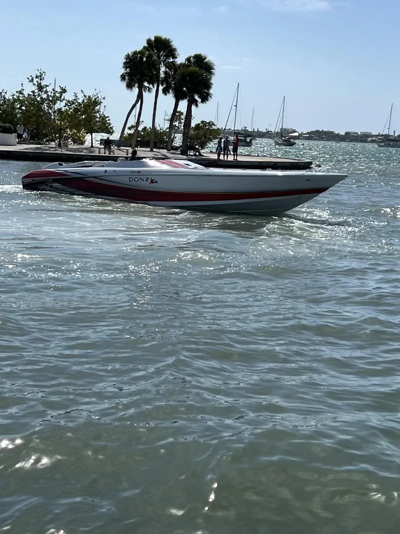 Slide: The Image of 2008 Donzi 43 ZR speedboat on water near palm trees and sailboats. - 4
