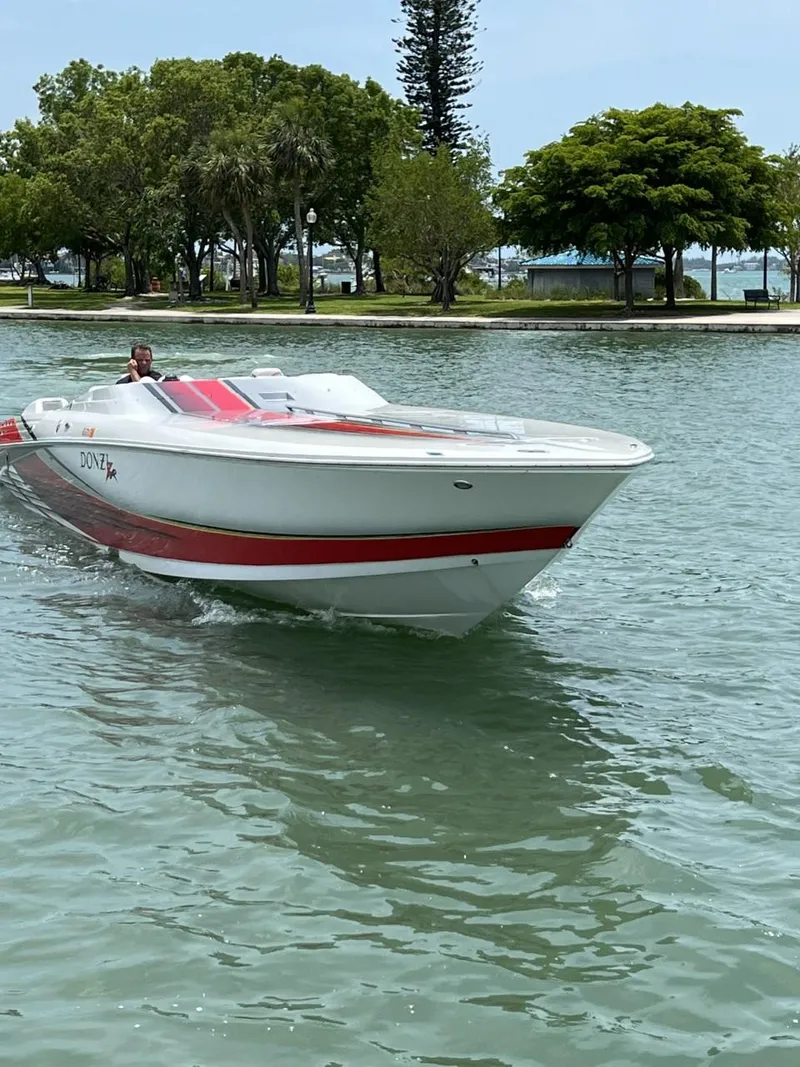 Slide: The Image of 2008 Donzi 43 ZR speedboat cruising on a calm lake with trees in the background. - 6