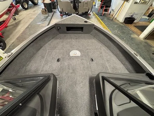 Slide: The Image of 2025 Crestliner 1650 Hawk boat interior with carpeted deck and storage compartments. - 10