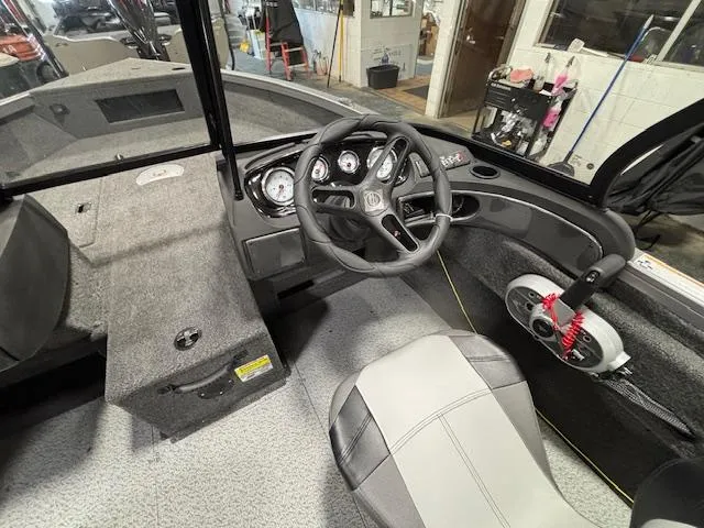 Slide: The Image of 2025 Crestliner 1650 Hawk boat interior with steering wheel and dashboard controls. - 18