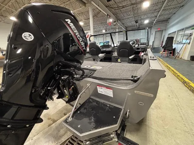 Slide: The Image of 2025 Crestliner 1650 Hawk boat with Mercury outboard motor in a showroom. - 22