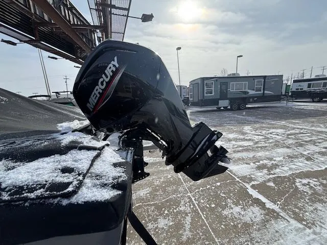 Slide: The Image of 2025 Crestliner 1650 Hawk with Mercury outboard motor in snowy outdoor setting. - 24