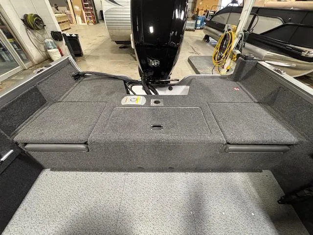 Slide: The Image of 2025 Crestliner 1650 Hawk boat interior with motor, showcasing spacious deck and storage. - 4