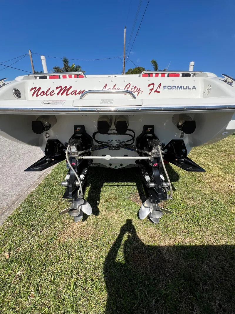 Slide: The Image of 2016 Formula 353 FASTech boat rear view, dual propellers, parked on grass under clear blue sky. - 12