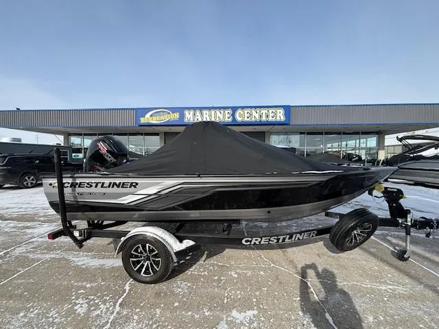 Slide: The Image of 2025 Crestliner 1750 Fish Hawk boat with cover at a marine center. - 1